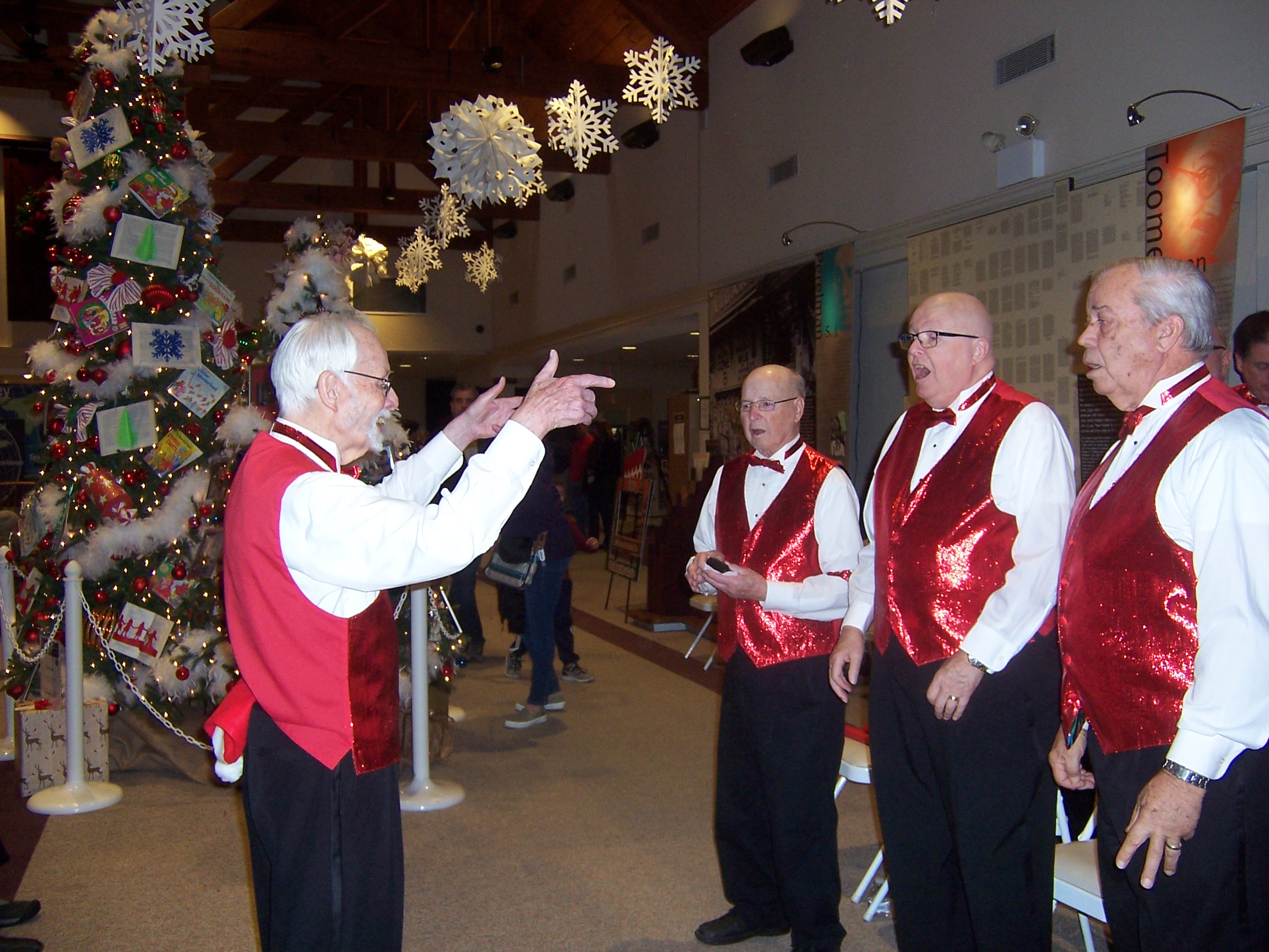 The chorus singing, onstage, in festive attire (2 of 4)